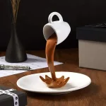 Kaffeetasse, aus der flüssige Schokolade in eine Schale fließt, dekoratives und essbares Kunstwerk.