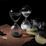 Sanduhr aus Glas mit schwarzem und weißem Muster, dekoratives wissenschaftliches Objekt.