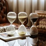 Drei elegante Kristall-Glasuhren im Vintage-Design, die auf einem Tisch stehen, mit detaillierten Mustern und reflektierenden Oberflächen.