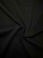 Nahaufnahme eines schwarzen Stoffes mit weichem Faltenwurf, ideal für Textil- oder Modeanwendungen.
