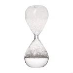 Sanduhr aus Glas mit weißen Sandkörnern, ideal als Dekoration oder wissenschaftliches Sammlerstück.