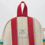 Schulrucksack mit Namensschild und roten Trägern, ideal für Kinder.
