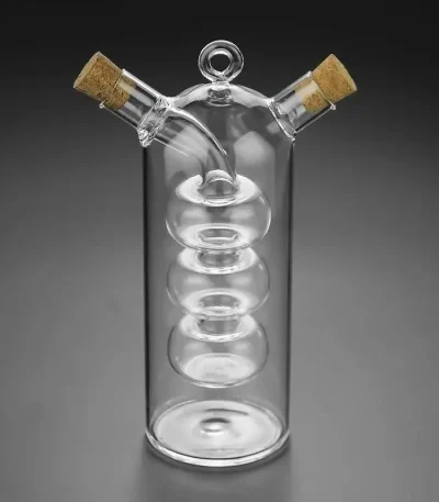 Transparentes wissenschaftliches Glas mit spiralförmiger Innenstruktur und zwei seitlichen Ausgüssen, verschlossen mit Korken, ideal für Experimente.