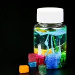 Glasfläschchen mit bunten, schimmernden Kristallen und flüssigen Farbströmen, ideal für wissenschaftliche Dekorationen und Experimente.