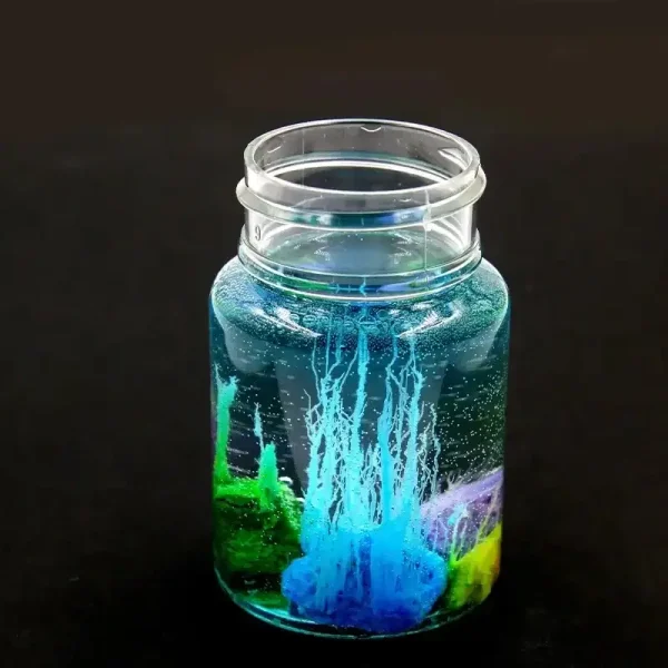 Glasbehälter mit blauer Flüssigkeit und bunten chemischen Reagenzgläsern, ideal für wissenschaftliche Dekorationen und Experimente.
