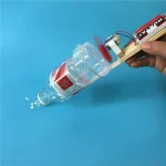 Selbstgebautes Wasserflugzeug mit Elektromotor, das eine Plastikflasche als Treibstoffquelle nutzt, auf blauem Hintergrund.