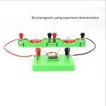 Demonstration eines elektromagnetischen Schwung-Experiments mit grüner Basis, Drähten, Magneten und Spulen, zeigt die Grundlagen der elektromagnetischen Induktion.