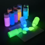 Leuchtende Farbfläschchen in verschiedenen Farben, die im Dunkeln leuchten, ideal für wissenschaftliche Dekorationen und kreative Projekte.