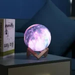 LED-Mondlampe auf Holzständer, realistische Mondoberfläche mit leuchtendem Himmel in Blau und Lila.
