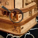Detailliertes Holz-Puzzle mit einer Lupe, das auf einem runden Holztablett präsentiert wird, ideal für Wissenschafts- und Dekorationsliebhaber.