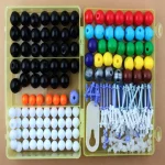 Bunte Schul- und Lernspielzeug-Set mit bunten Perlen, Stiften und Zubehör für kreative und pädagogische Aktivitäten.