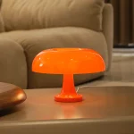 Moderne orangefarbene Tischleuchte im Retro-Design, ideal für Wohnzimmer oder Schlafzimmer, schafft eine warme und gemütliche Atmosphäre.