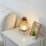 Elegante skandinavische Kerzenlampe aus Holz und Glas, die warmes Licht spendet, ideal für gemütliche Abende und moderne Raumdekoration.