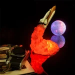 Detailliertes Modell eines Raumfahrzeugs beim Start, mit leuchtendem Feuer und Rauch, vor einem Mond-Hintergrund, ideal für Wissenschafts- und Raumfahrtdekorationen.