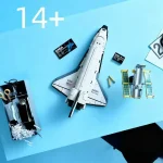 Detailaufnahme eines Raumfahrtmodells mit Satelliten, Batterien und Werkzeugen auf einem blauen Hintergrund, geeignet für Wissenschafts- und Technikliebhaber.