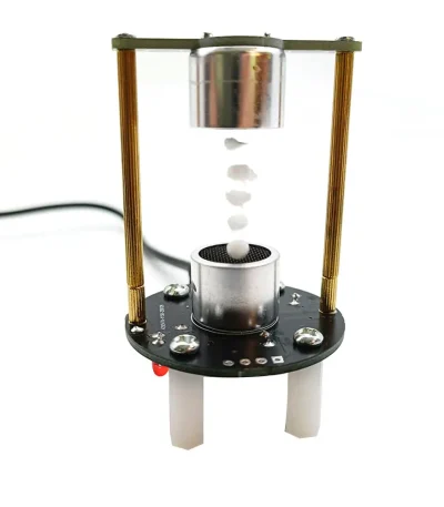 Wissenschaftliches Experiment mit magnetischer Kugel, das den Kugelstoß in einem transparenten Glas zeigt, auf einer technischen Plattform mit Kabel.