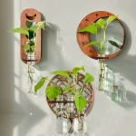 Dekorative Wandgestaltung mit grünen Pflanzen in Glasvasen, befestigt an Holzdekor-Elementen, schafft eine natürliche und moderne Atmosphäre.