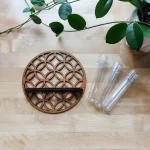 Dekorativer Pflanzenhalter aus Holz mit drei Glasröhren, ideal für Pflanzen oder wissenschaftliche Präsentationen, auf hellem Holztisch mit grünen Pflanzen im Hintergrund.