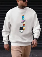 Sweatshirt mit Illustration eines Weltraumforschers, der einen Turm aus balancierenden Planeten betrachtet.