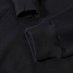 Nahaufnahme eines schwarzen Sweatshirts mit geripptem Bündchen, Stoffdetails sichtbar, modisches und bequemes Kleidungsstück.