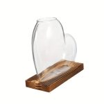 Transparentes Glasherz auf Holzsockel, dekoratives wissenschaftliches Kunstobjekt.