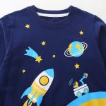 Kinderkleidung mit Weltraummotiv, einschließlich Rakete, Sterne, Planet und Teleskop, perfekt für Astronomie- und Weltraumforschungsbegeisterte.