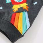 Hochwertige Stickerei eines bunten Raketenmotivs auf dunklem Textil, ideal für Dekoration oder Kleidung mit wissenschaftlichem Thema.