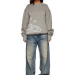 Lässiger grauer Pullover mit abstraktem Design, kombiniert mit weiten, ausgewaschenen Jeans, ideal für einen entspannten wissenschaftlichen Dekorationsstil.