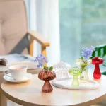 Dekorative Glasblumen in verschiedenen Farben auf einem Tisch, ideal für wissenschaftliche Dekorationen und kreative Raumgestaltung.