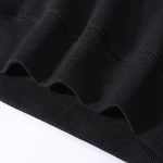 Detail eines schwarzen Sweatshirt-Ärmels mit gerippter Verarbeitung, perfekt für einen lässigen und wissenschaftlichen Stil.
