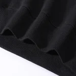 Detail eines schwarzen Sweatshirt-Ärmels mit gerippter Verarbeitung, das das Thema "Es ist mein DNA" für eine wissenschaftliche Dekoration illustriert.