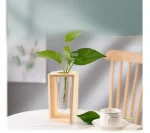 Holzvase mit einer grünen Pflanze in einem modernen Interieur, natürliche und elegante Dekoration für Zuhause oder Büro.
