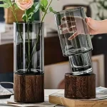 Elegante Blumenvasen aus transparentem Glas mit Holzsockel, ideal für moderne Dekorationen und Blumenarrangements.