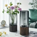 Elegante Blumenvasen aus Glas mit Holzsockel, ideal für moderne Dekorationen und Blumenarrangements.