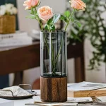 Elegante Blumen im wissenschaftlichen Vase mit Holzsockel, ideal für Dekoration und wissenschaftliche Präsentationen.