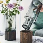Elegante Blumen im Glas mit Holzsockel, modernes Dekorstück für Zuhause oder Büro, stilvolle Raumgestaltung.