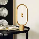 Modernes Pendeluhren-Design mit goldenen Kugeln und ovalem Rahmen, ideal für wissenschaftliche Dekorationen und stilvolle Inneneinrichtung.